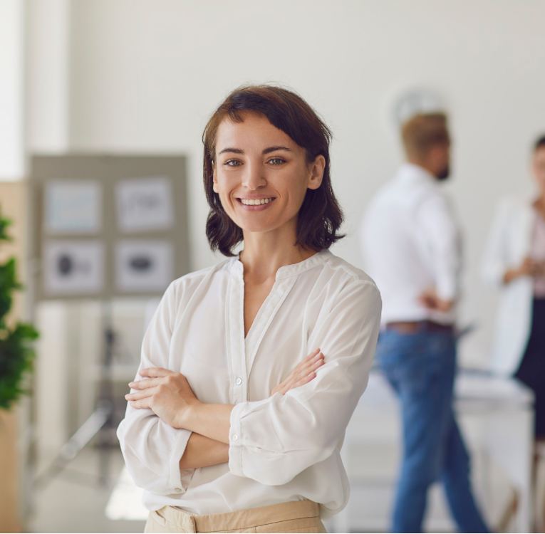 Female employee in an office with colleagues in the background at a company working towards pay transparency and equal pay.