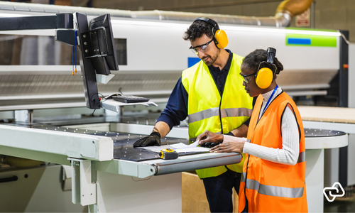 Two production employees using digital time tracking on the production floor.