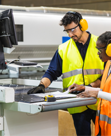 Two production employees using digital time tracking on the production floor.