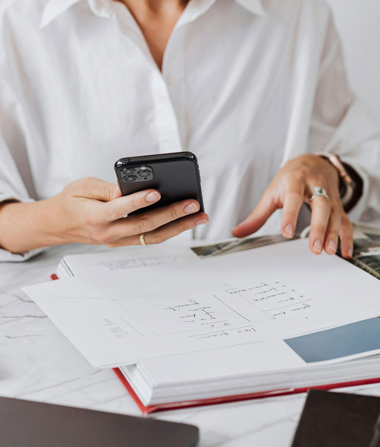 Compliance officer managing regulatory controls via a smartphone in an office environment.