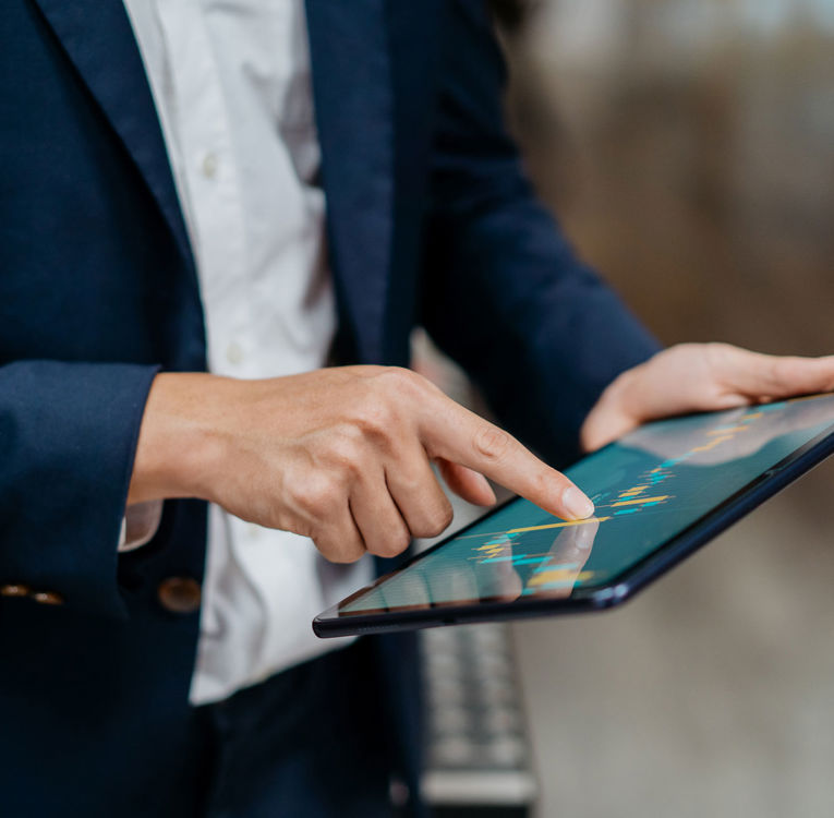 Close-up of hands using a tablet for data-driven workforce management and scheduling.