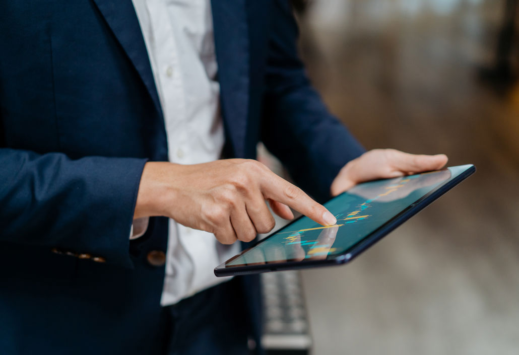 Business professional using a tablet to review data-driven insights, illustrating how to create effective work schedules with real-time planning tools.