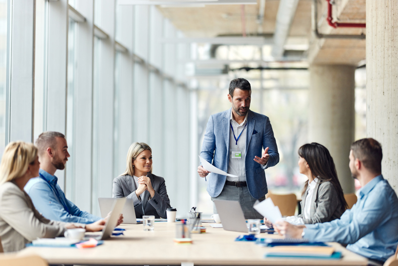 Manager holding a meeting with their team about implementing an AI-based workforce management solution to improve staff scheduling, time tracking, and workforce optimisation.