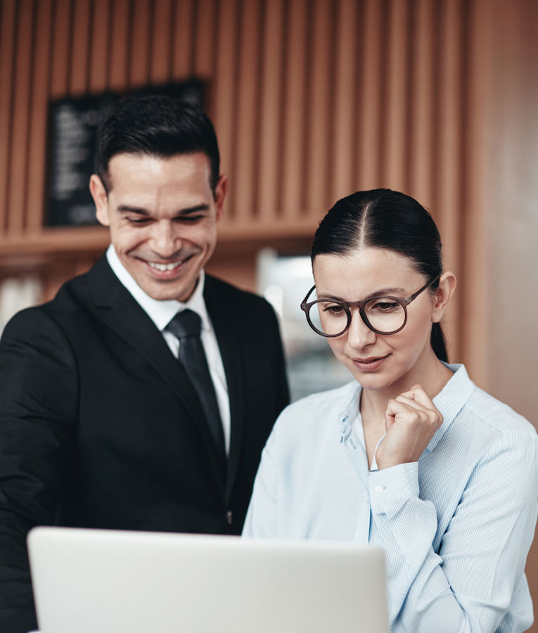Two hospitality managers discussing shift planning and workforce management in a hotel setting.