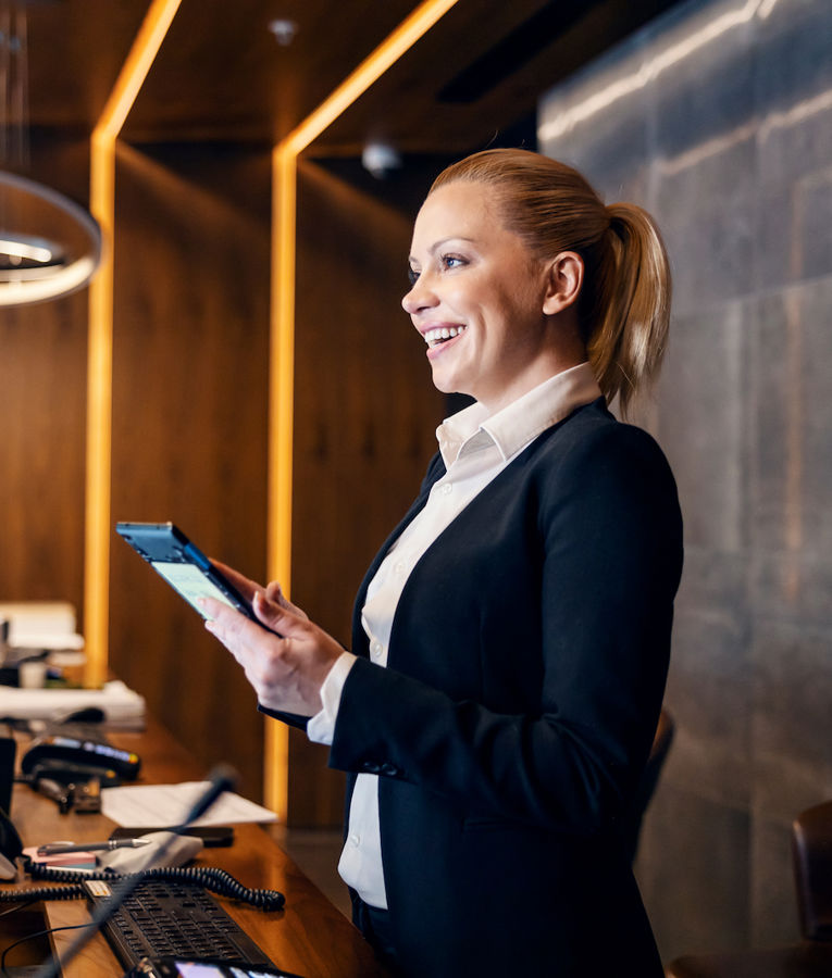 A friendly hotel receptionist welcoming guests and managing check-ins at the reception desk.