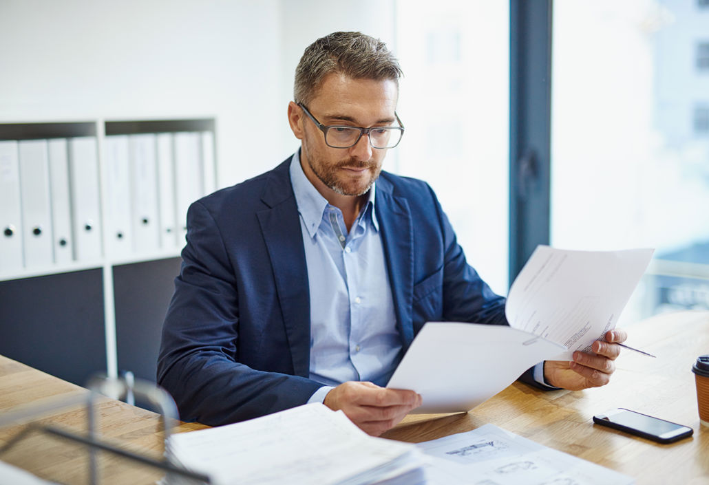 Business professional analysing workforce reports and schedules, focusing on compliance, labour costs, and strategic planning.