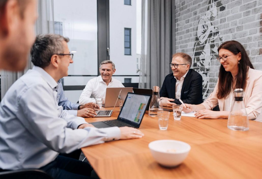 Management team in a strategy meeting reviewing workforce performance and scheduling insights to improve operational planning and resource allocation.